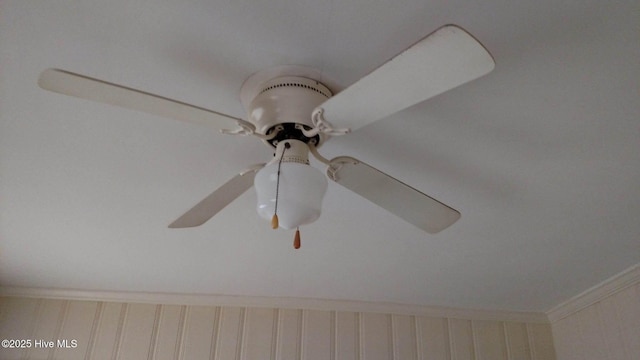 interior details featuring ornamental molding and a ceiling fan