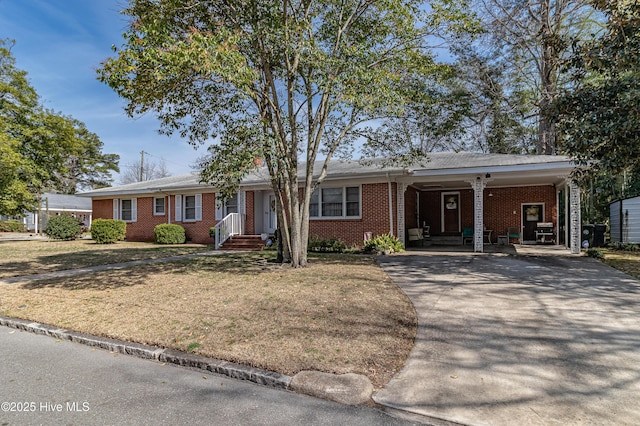 single story home featuring an attached carport, brick siding, driveway, and a front lawn