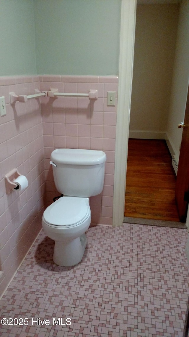 bathroom featuring a wainscoted wall and toilet