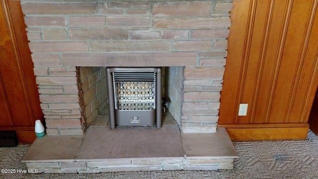 interior details featuring heating unit and a fireplace with raised hearth