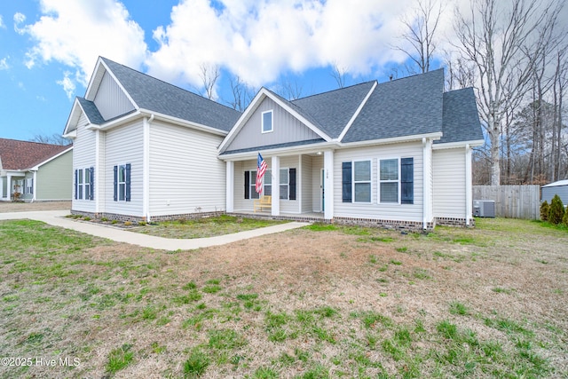 view of front of property with a front lawn, fence, cooling unit, board and batten siding, and roof with shingles