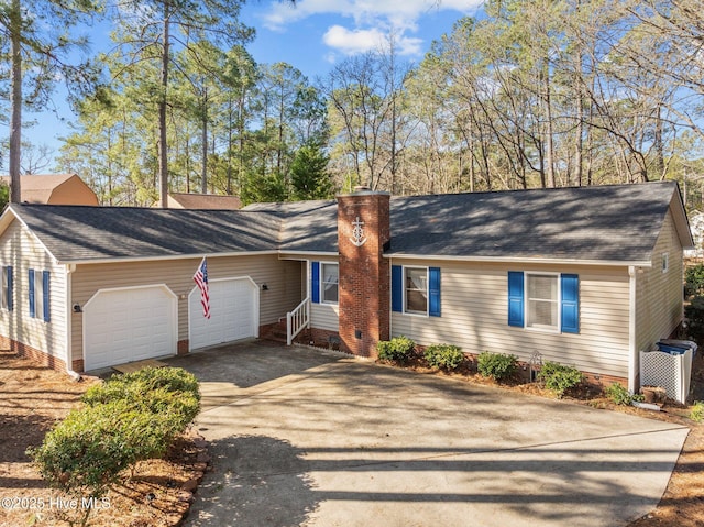 view of front of house featuring an attached garage, a chimney, driveway, and roof with shingles