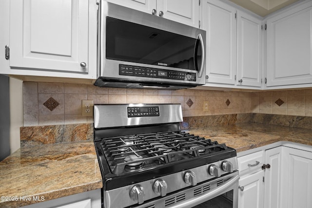 kitchen with white cabinets, tasteful backsplash, and stainless steel appliances