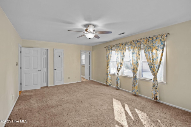 unfurnished bedroom with carpet flooring, visible vents, baseboards, and ceiling fan