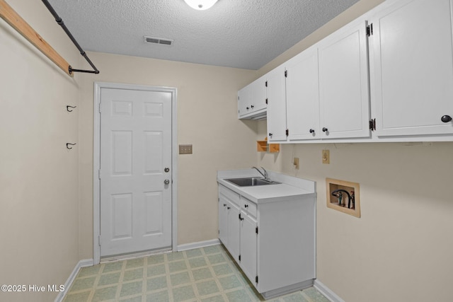 clothes washing area with visible vents, baseboards, washer hookup, cabinet space, and a sink