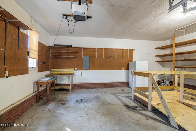 garage featuring a workshop area, electric panel, a garage door opener, and freestanding refrigerator