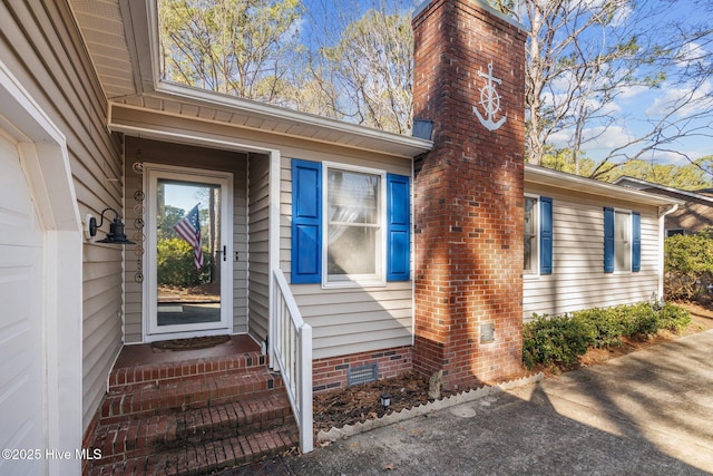 entrance to property with a chimney and crawl space