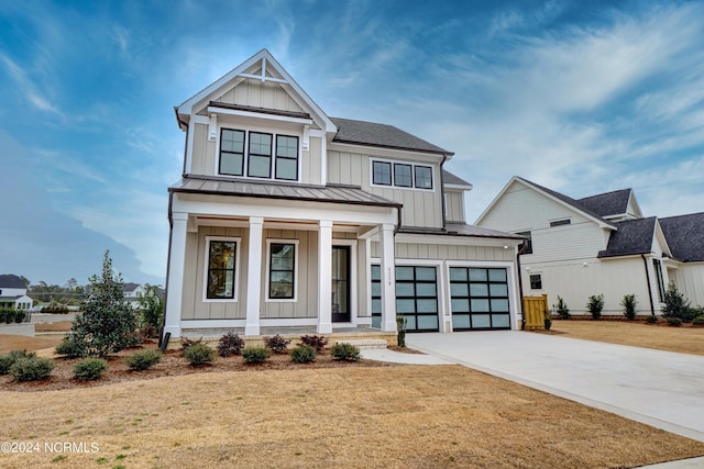 modern farmhouse style home featuring driveway, a standing seam roof, covered porch, board and batten siding, and metal roof