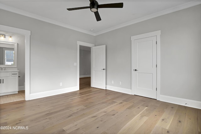 unfurnished bedroom with connected bathroom, light wood-style flooring, baseboards, and ornamental molding