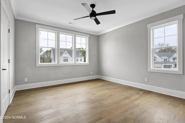 unfurnished room featuring visible vents, wood-type flooring, baseboards, and ornamental molding