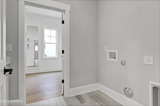 laundry room featuring baseboards, light wood-type flooring, gas dryer hookup, hookup for a washing machine, and electric dryer hookup