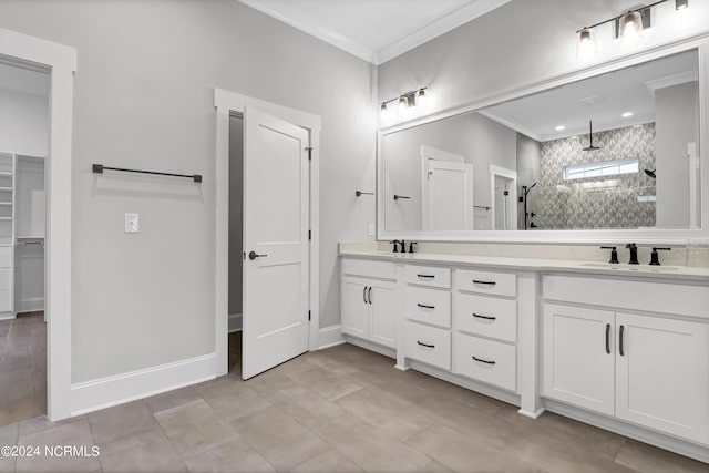 bathroom with a sink, crown molding, double vanity, and a tile shower