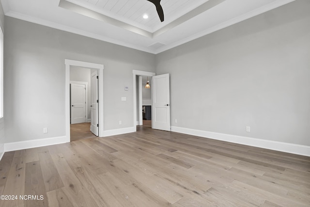 unfurnished bedroom with baseboards, a tray ceiling, recessed lighting, light wood-style floors, and crown molding