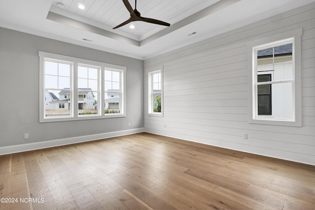 unfurnished room featuring a tray ceiling, visible vents, ceiling fan, and hardwood / wood-style flooring