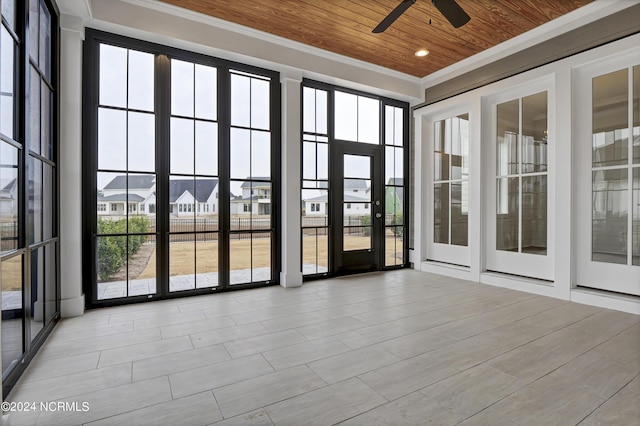 unfurnished sunroom featuring a residential view, wood ceiling, and a ceiling fan