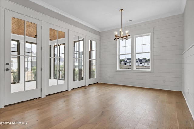 interior space featuring ornamental molding, wood finished floors, and a chandelier