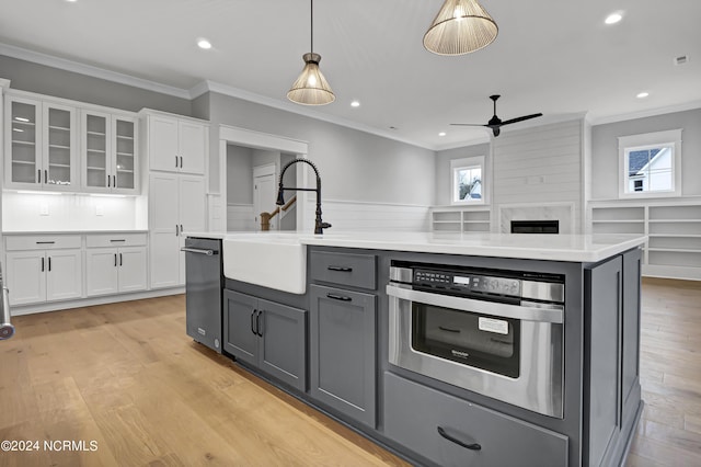 kitchen with gray cabinetry, a sink, white cabinetry, light wood finished floors, and ceiling fan