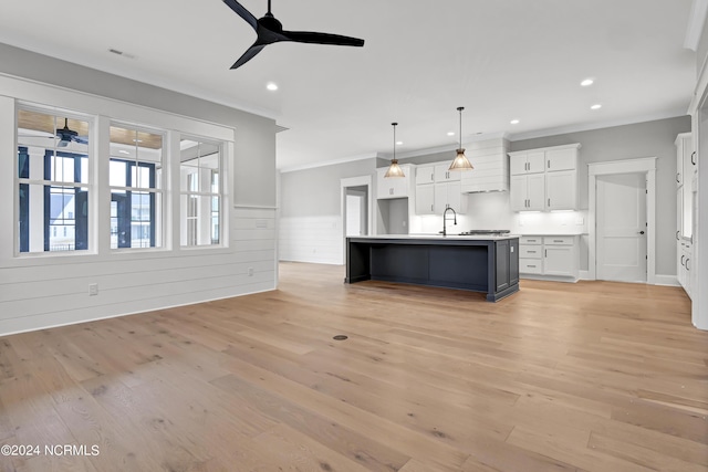 kitchen featuring light wood finished floors, visible vents, ceiling fan, ornamental molding, and white cabinetry