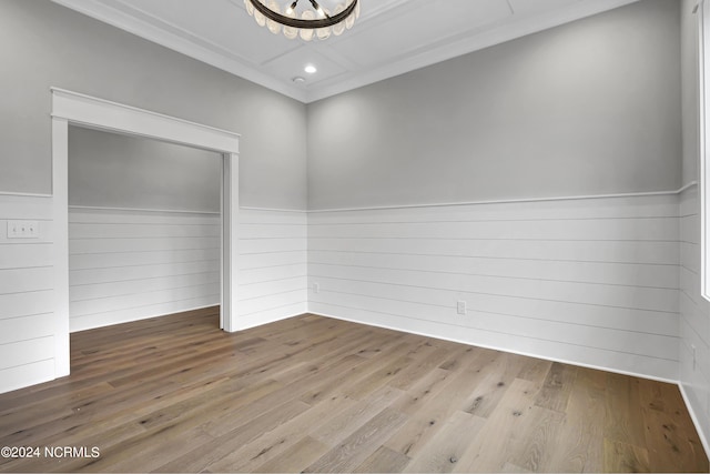 empty room featuring a wainscoted wall, recessed lighting, wood walls, and wood finished floors