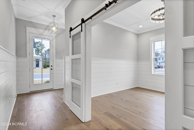 entryway with a wainscoted wall, a healthy amount of sunlight, and ornamental molding