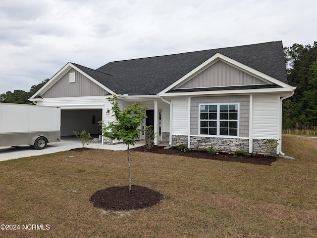 view of front of property featuring a front yard, a garage, stone siding, and a shingled roof