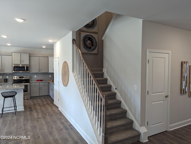 stairs with recessed lighting, wood finished floors, and baseboards