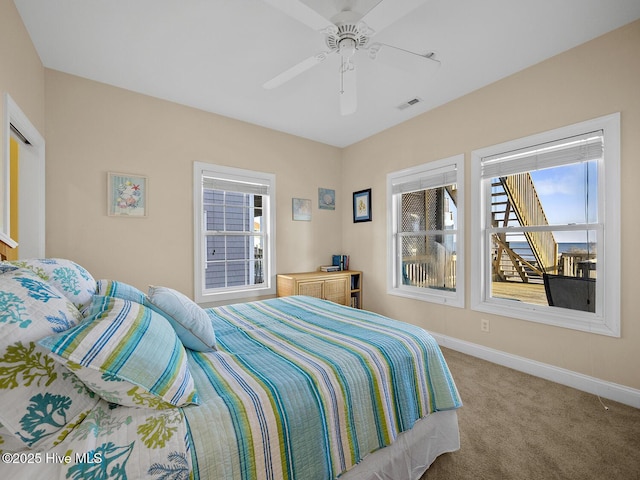 bedroom featuring visible vents, baseboards, carpet, and a ceiling fan