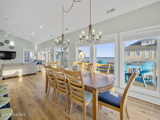 dining space with visible vents, plenty of natural light, light wood-type flooring, and lofted ceiling