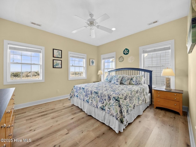 bedroom with visible vents, a ceiling fan, light wood-type flooring, and baseboards