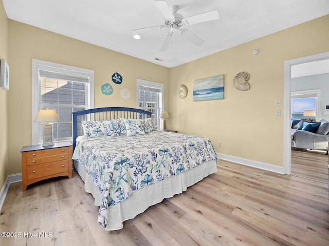 bedroom with visible vents, a ceiling fan, light wood-type flooring, and baseboards