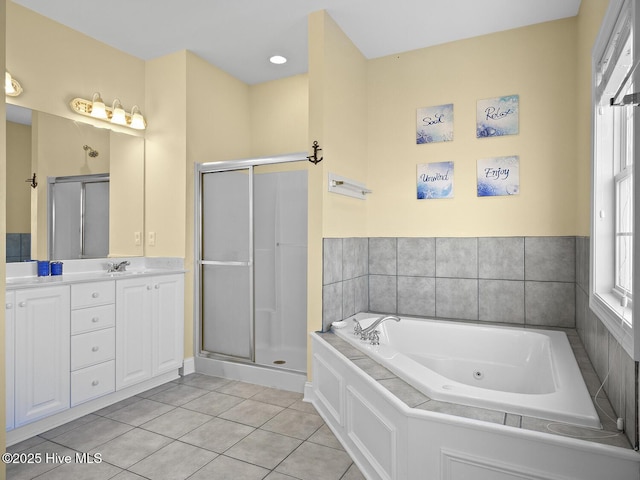 bathroom featuring a jetted tub, a stall shower, vanity, and tile patterned flooring