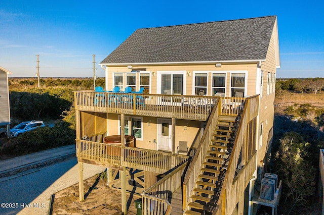 back of property featuring central air condition unit, stairs, a deck, and roof with shingles