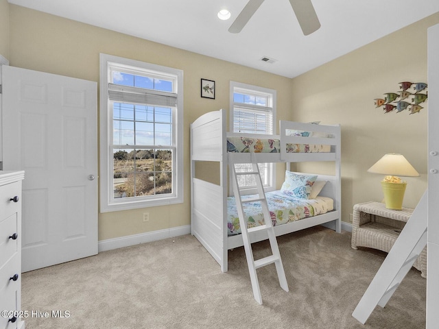 carpeted bedroom with visible vents, baseboards, and ceiling fan