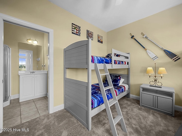 carpeted bedroom featuring tile patterned floors, baseboards, and connected bathroom