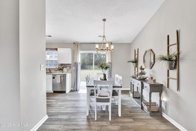 dining room featuring an inviting chandelier, wood finished floors, and baseboards