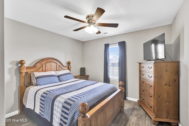 bedroom featuring ceiling fan, wood finished floors, visible vents, and baseboards