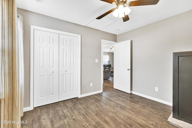 unfurnished bedroom with a closet, ceiling fan, baseboards, and wood finished floors