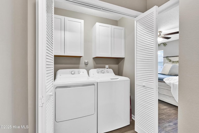 clothes washing area with wood finished floors, a ceiling fan, cabinet space, a textured ceiling, and washer and dryer