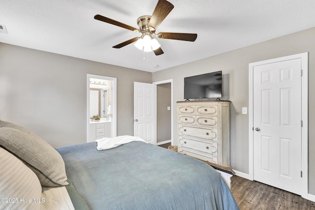 bedroom featuring visible vents, connected bathroom, baseboards, a ceiling fan, and dark wood-style flooring