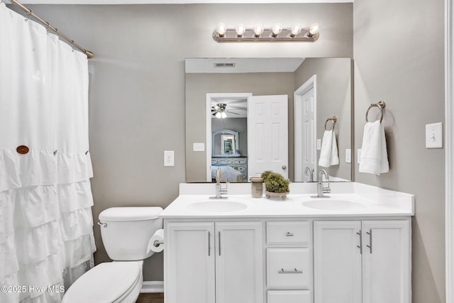 ensuite bathroom with visible vents, connected bathroom, ceiling fan, double vanity, and a sink