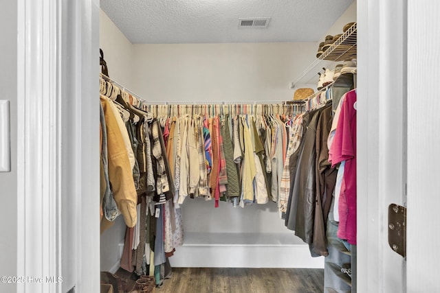 spacious closet featuring visible vents and wood finished floors