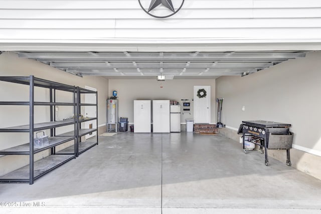 garage with fridge, baseboards, freestanding refrigerator, and electric water heater