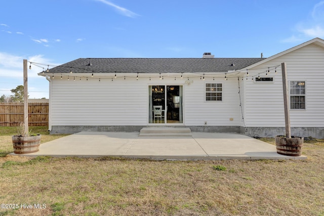 back of house featuring a patio area, a yard, fence, and a shingled roof