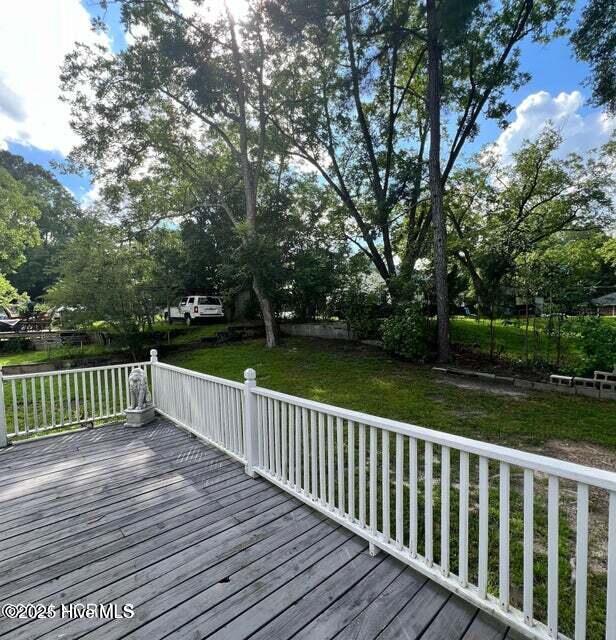 wooden deck featuring a yard