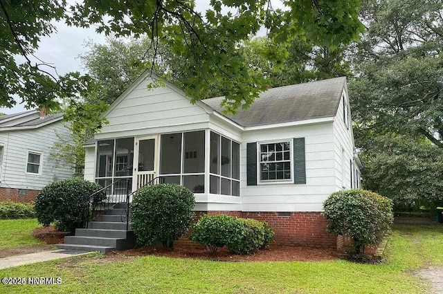 bungalow-style home with crawl space, a front lawn, and a sunroom