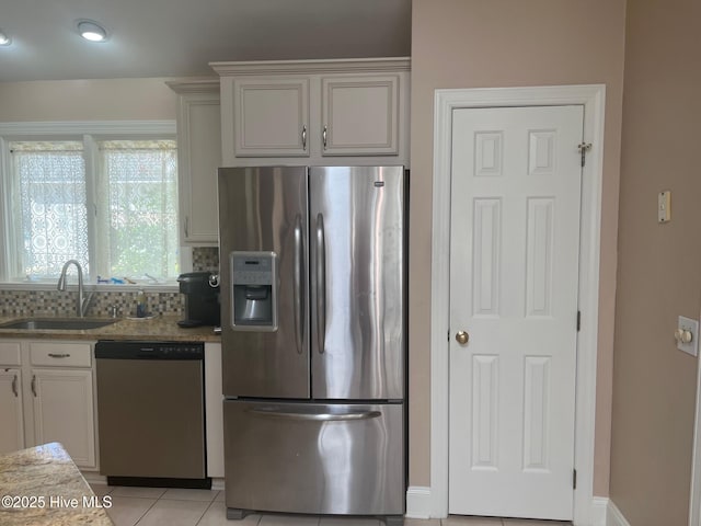 kitchen featuring light tile patterned flooring, stainless steel appliances, tasteful backsplash, and a sink