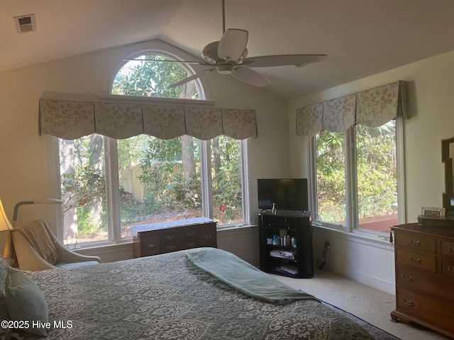 carpeted bedroom with visible vents, vaulted ceiling, multiple windows, and a ceiling fan