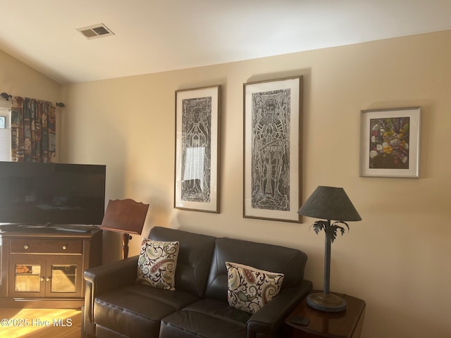 living room with visible vents and vaulted ceiling