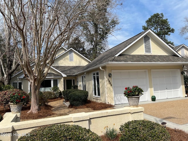 view of front of house featuring stucco siding, an attached garage, and roof with shingles