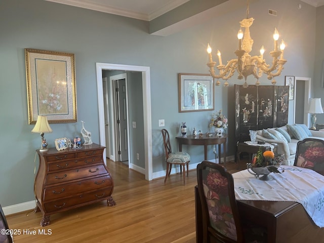 dining area featuring wood finished floors, visible vents, baseboards, ornamental molding, and a notable chandelier